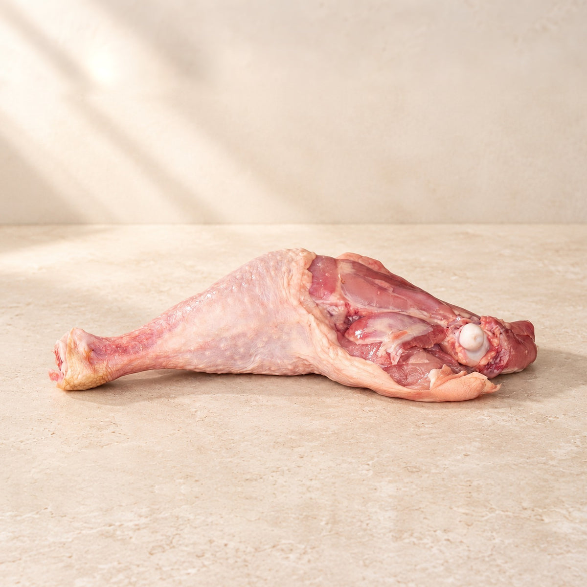 Bio-Hähnchenschenkel, roh, auf hellem Kalkstein