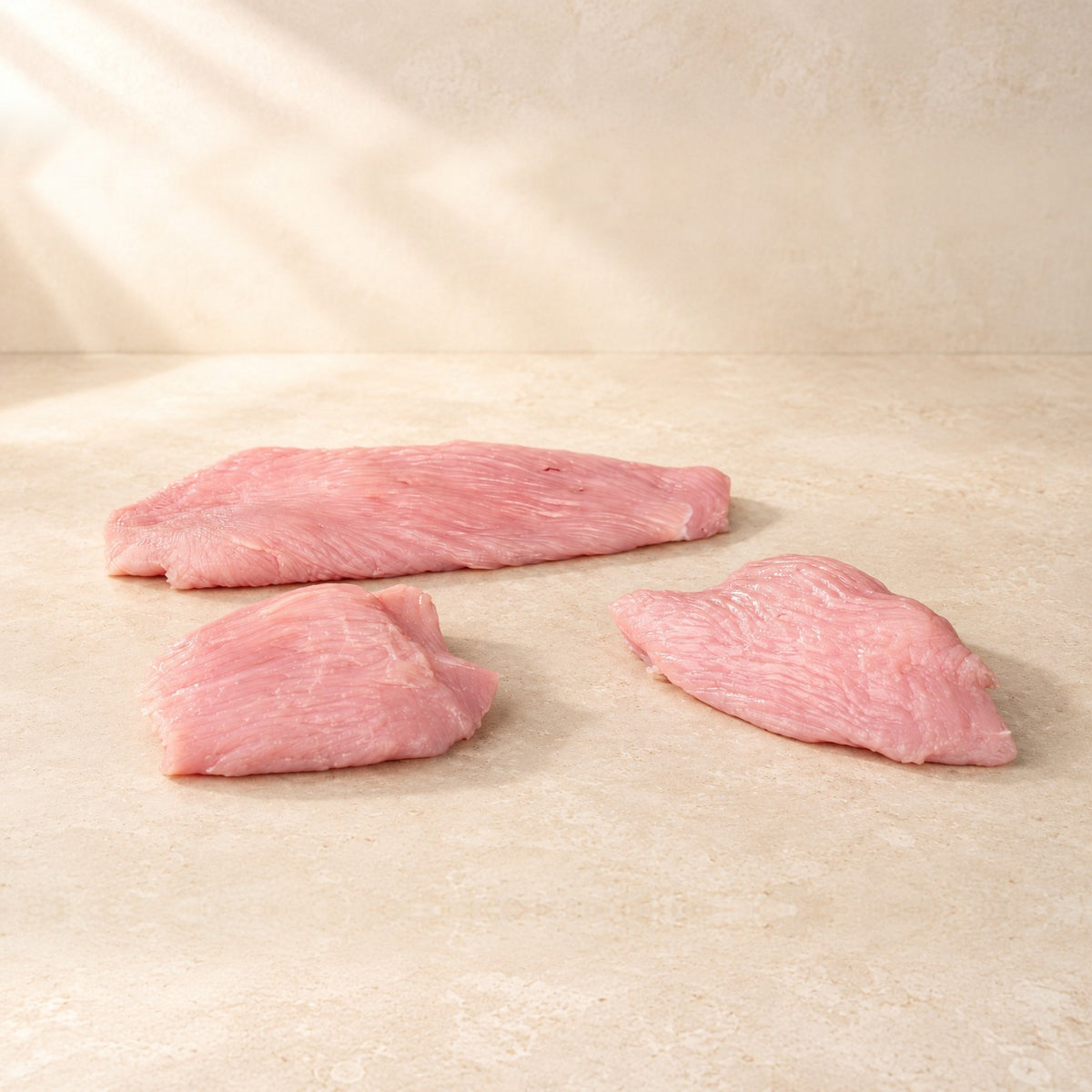 Bio-Putenschnitzel, roh, auf hellem Kalkstein